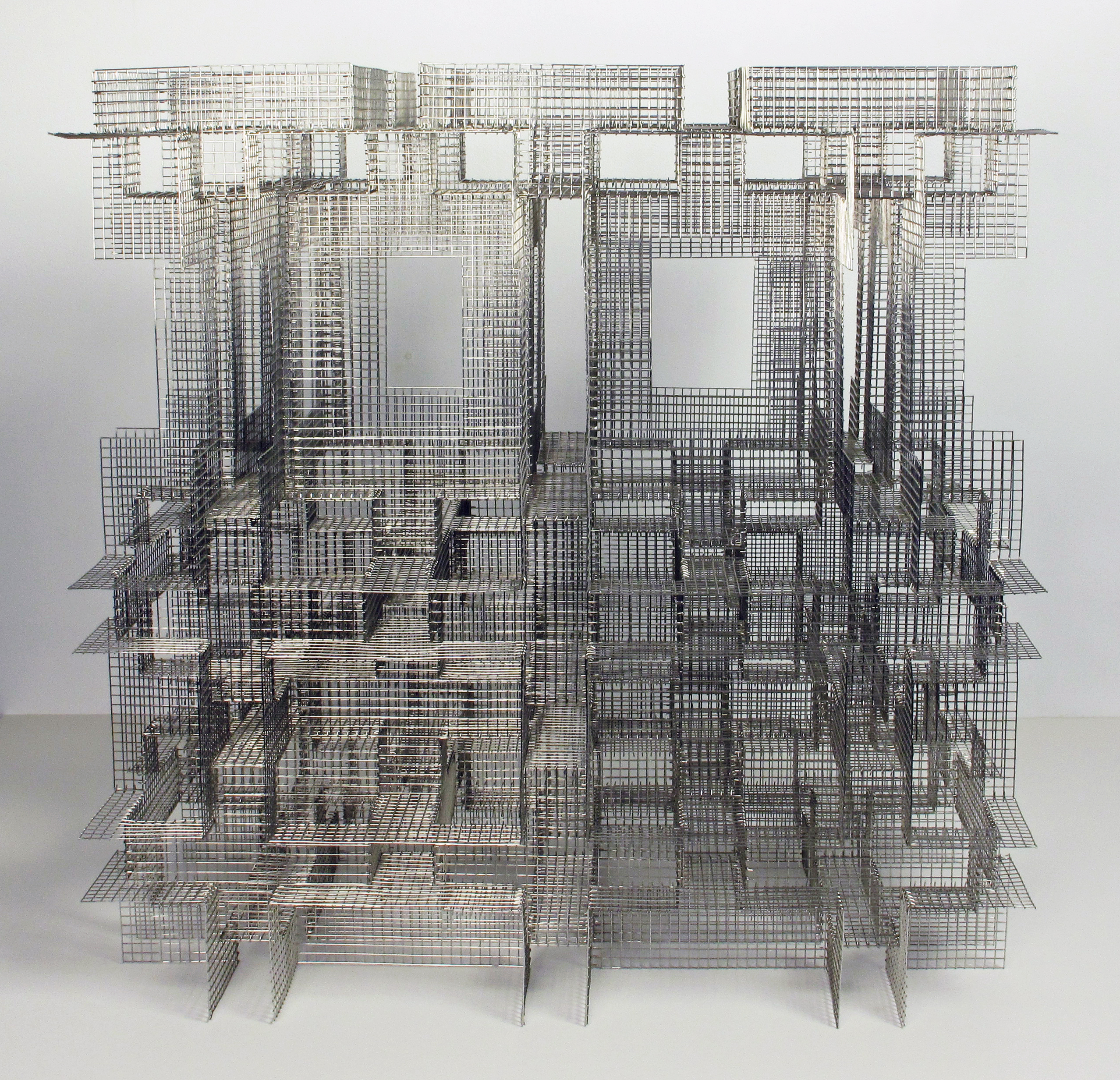 A sculpture made up of multiple grid-like forms in stainless steel mesh. 