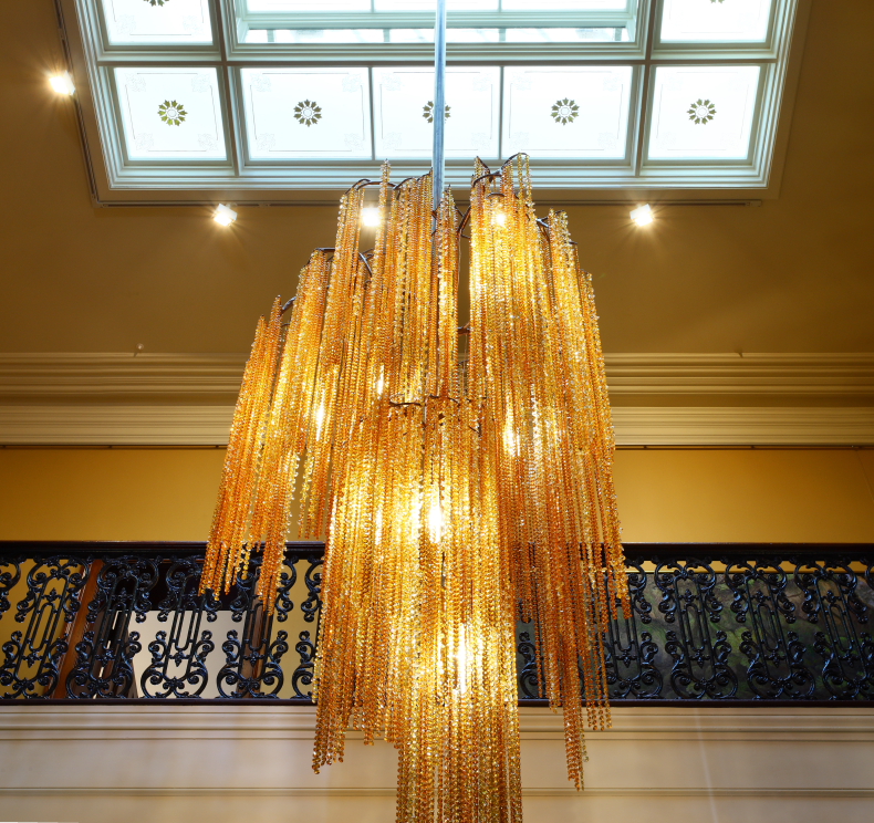 A chandelier made from amber crystal beads that cascade from branch-like arms.